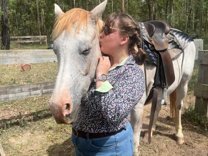 a woman kissing her horse