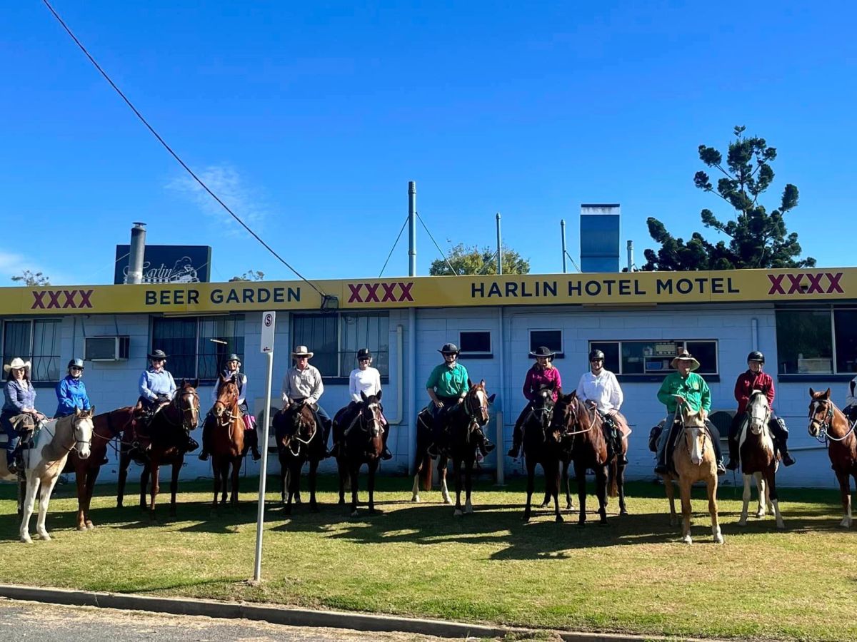 a group of people on horses posing for the camera in front of a building