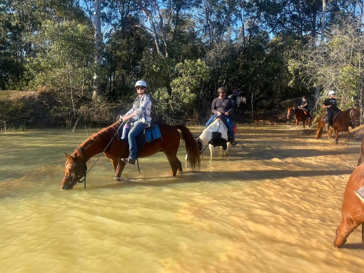 a group of people riding horses on a river
