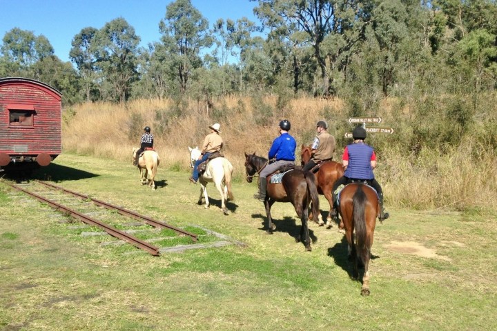 a group of people riding horses on a field
