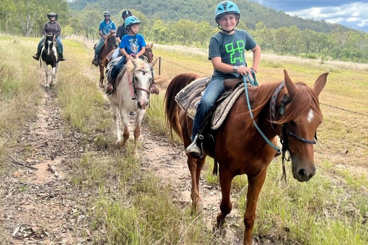 a group of people riding horses on a field