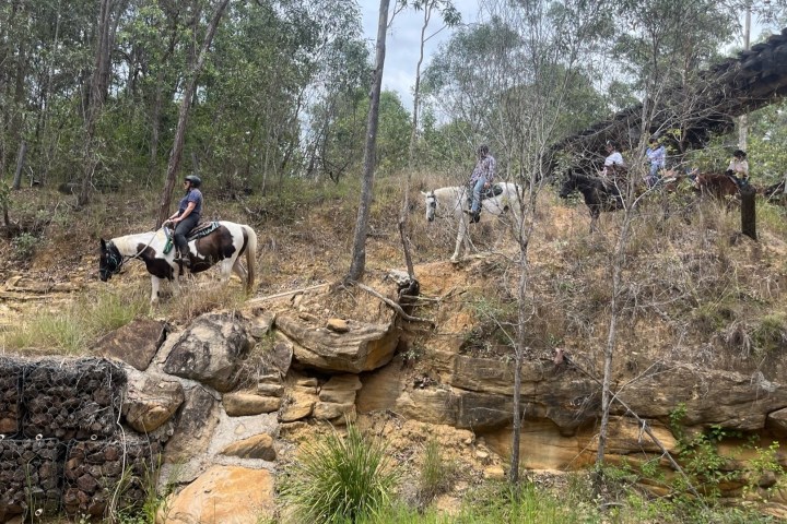 a group of people riding horses on a rocky mountain